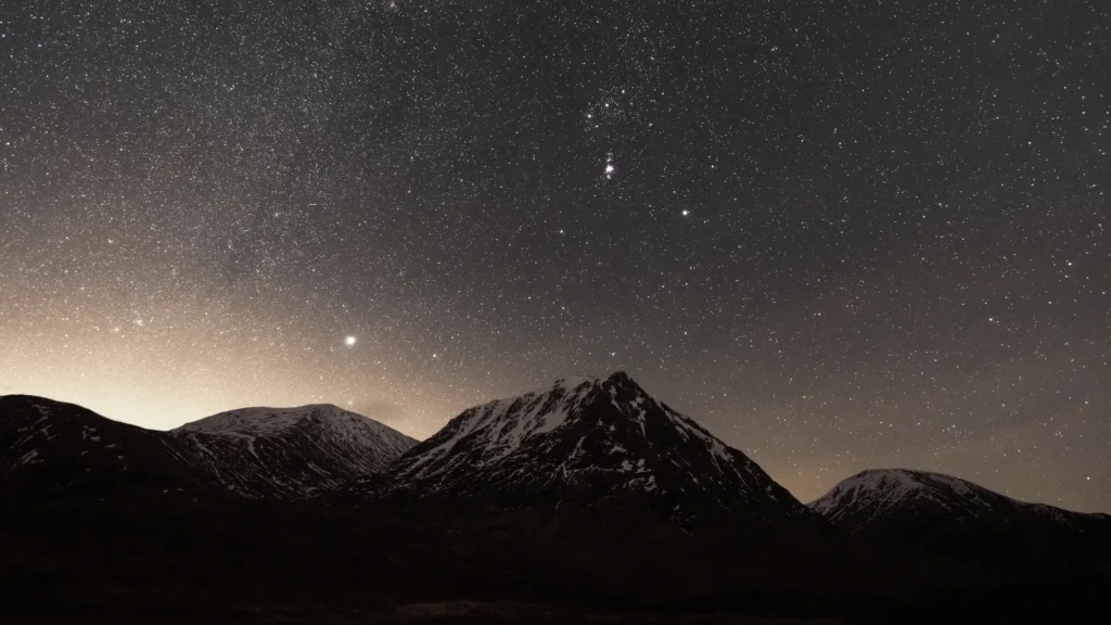 Night sky full of stars above a snow-dusted mountain range, hero image for Pinnacle's Facebook ad agency services